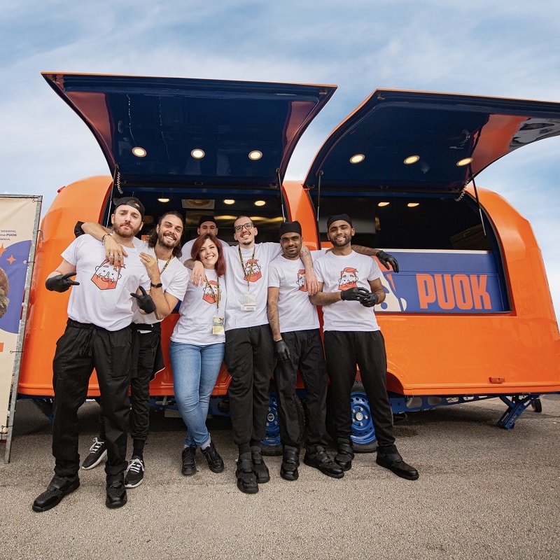 Team di PUOK davanti al food truck arancione